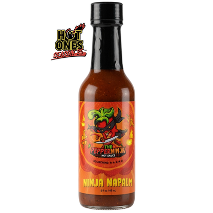 A 5 fl oz bottle of Hot Ones Seasoned Foods The Pepperninja Hot Sauce in Scorchio Scovino, featuring a black cap and a vibrant orange label with a green pepper character, set against a plain white background.