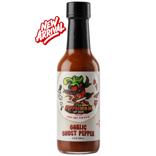 A bottle of The Pepperninja Garlic Ghost Pepper hot sauce on a white background with a red 'NEW ARRIVAL' badge in the top left corner. The bottle contains a reddish-brown sauce, has a black cap, and a white label featuring a cartoon pepper character.